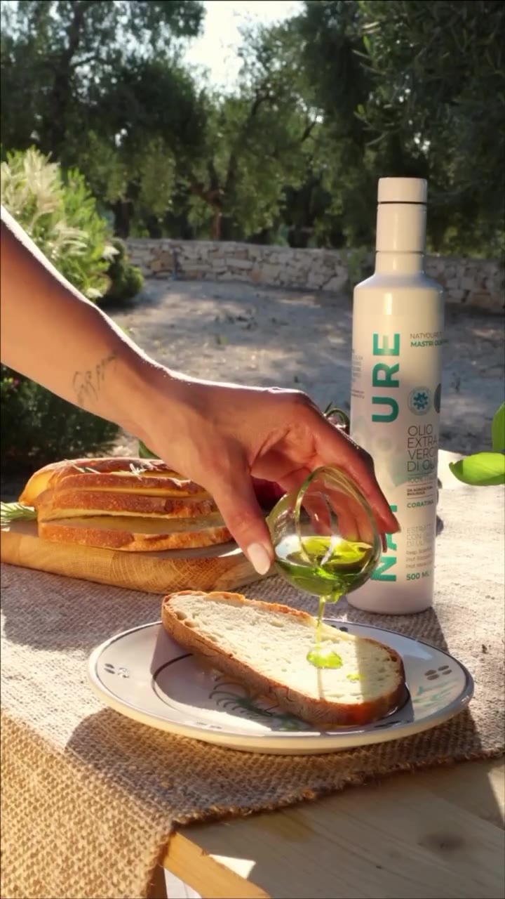 Olio Natyoure versato sul pane, tra gli ulivi